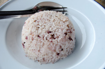 Steamed rice with chopsticks on wooden table