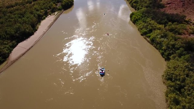 Aerial of people floating down the colorado river in a dry utah desert