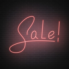 Neon Sale. Sale lettering script design. Neon sale sign on the brick wall