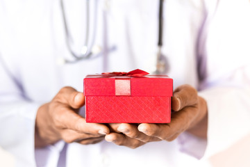 Doctor holding the red gift box in his hand