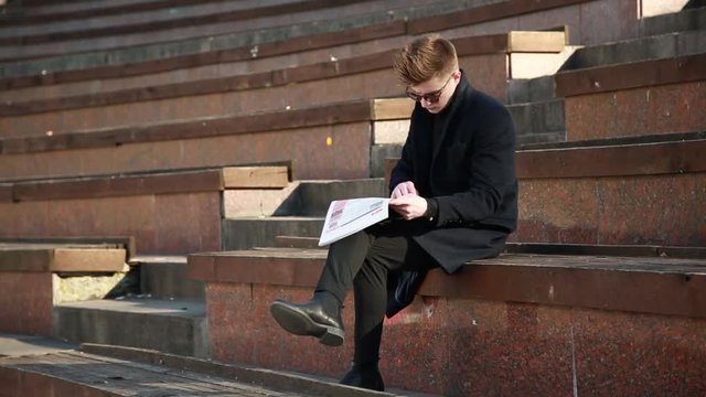 A young Man reads a nationalist Newspaper 'Nation' on the Street of Kiev Ukraine