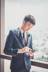 Businessman in suit and using modern smartphone in his office.. concept for business