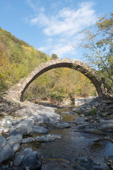 Fototapeta na wymiar The arch bridge in mountains, Alps, Italy