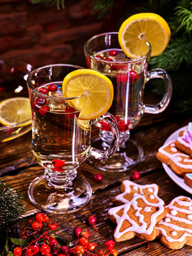 Christmas cookies on plate with fir branches. Christmas still life with pair mug decoration lemon slice hot drink on wooden table. Romantic atmosphere for holiday.