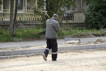male holding shovel and looking at sky