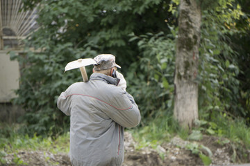 male holding shovel and looking at sky