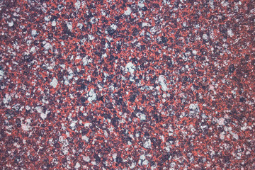 Marble texture imitating natural stone. Dark pink background with splashes of black and white. Daylight.