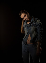 Fototapeta na wymiar Amazing young woman in trendy outfit posing at black background