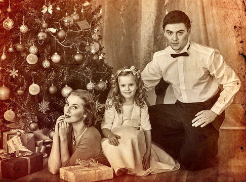 Christmas family photo with mother, father and girl in boxing day. Black and white Xmas vintage image with child by home interior.