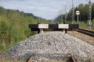wooden buffer stop with red stop sign ending rail tracks concept for limit, limitation restriction...