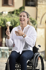 Giovane donna in sedia a rotelle allegra mangia il gelato