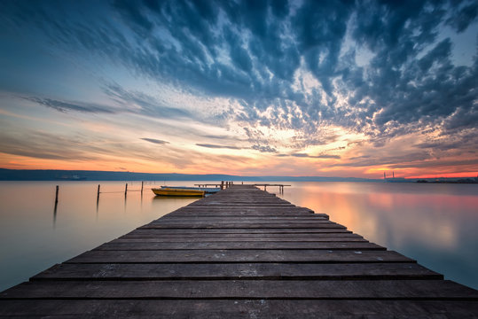 Lake sunset /
Magnificent long exposure lake sunset with boats and a wooden pier