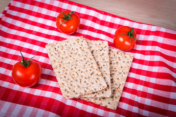 cracker with sesam and tomato on a red white towel