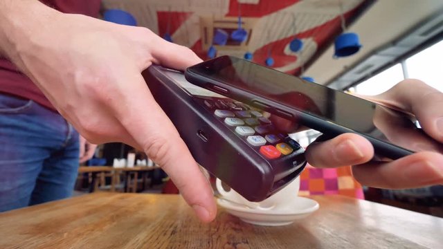 An NFC payment process shown in a coffee shop. 