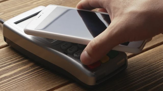 Close-up view of person using contactless payment with nfc techology.