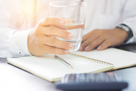businessman holding glass of drinking water
