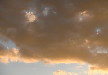 飛行機と夕日を浴びてオレンジ色に染まる雲「雲の風景」（明日につなげる、明日を信じて、持続力、持続する力、持続可能な、明日へ、明日への視点、視線などのイメージ）
