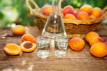 Apricot brandy in shot glass with raw apricots