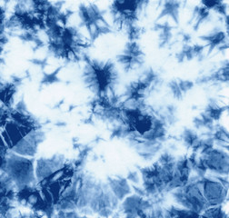 Abstract tie dyed fabric of indigo color on white cotton. Hand painted fabrics. Shibori dyeing - obrazy, fototapety, plakaty