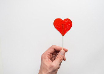 Hand holding shape of heart stick candy, love concept