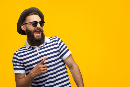 Stylish hipster man pointing away