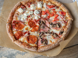 Homemade pizza set on paper at wooden table