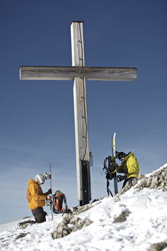 Two snowboarders near summit cross, Oberjoch, Bad Hindelang, Bavaria, Germany