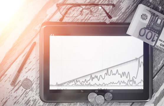 The graph of income growth. Electronic tablet with a graph of gr