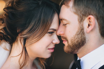 The faces of a man and a woman in profile during a tender kiss. Lovers are newlyweds.