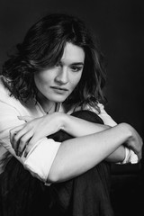 Black and white portraite of young, beautiful sad woman actress with short brown hair in the studio