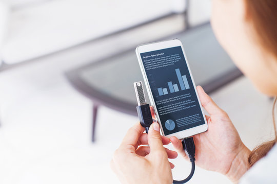 woman using otg usb with her mobile phone to see graphs