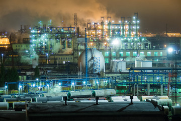 Oil refinery with pipes and distillation complexes at night