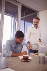 Businessman assisting young colleague in office