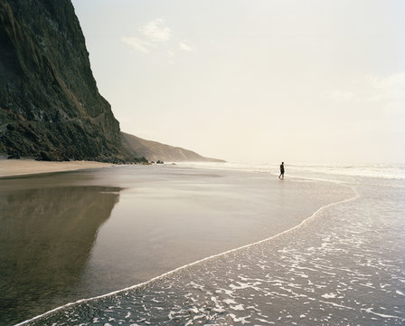 Man at the foot of the mountain, Praia Ribeira Seca, northeast of village Cruzinha, coastal way to Cha d'Igreja, Santo Antao, Ilhas de Barlavento, Republic of Cape Verde, Africa