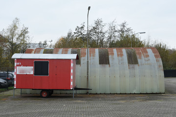 kleine opslagloods van golfplaten met schaftkeet van aannemingsbedrijf op een industrieterrein