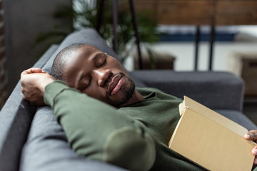 Obraz premium african american man sleeping on sofa