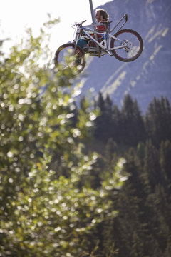 Downhill mountain biker in a chairlift, Morzine, Haute-Savoie, France