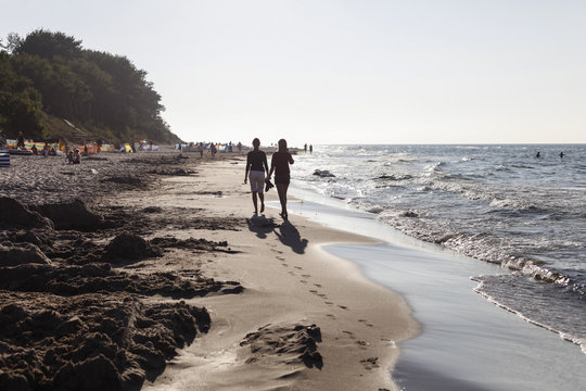 Two young women walking along the beach, Baltic Sea, Wittow Peninsula, Island of Ruegen, Mecklenburg West-Pomerania, Germany