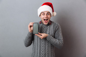 Excited screaming emotional man wearing christmas santa hat