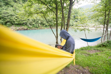 Man sitting in hammock near water