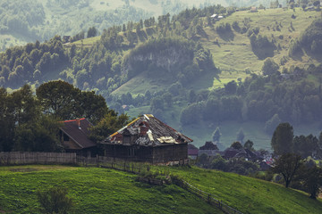 Rural landscape with traditional Romanian wooden houses uphill in Magura village, Brasov county,...