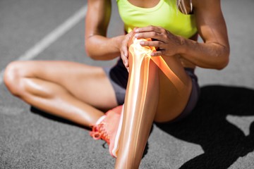 Low section of sportswoman suffering from knee pain - Powered by Adobe