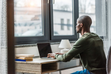 african american man with laptop at home