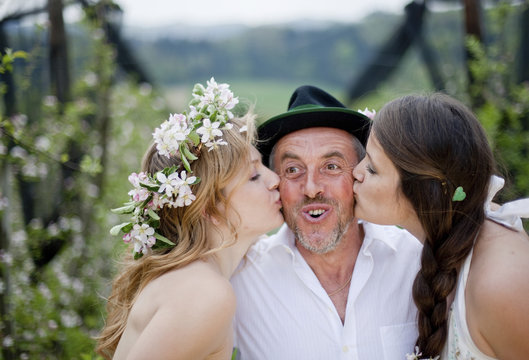 Two young women kissing a fruit farmer, Riegersburg, Styria, Austria