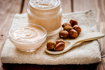 spa concept with almond nuts and scrub on wooden background