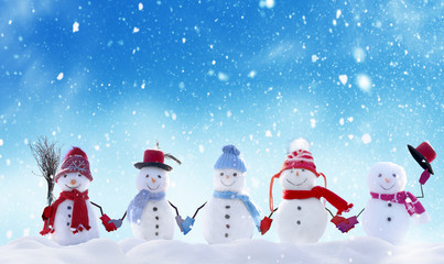 Merry Christmas and happy New Year greeting card with copy-space.Many snowmen standing in winter Christmas landscape.Winter background