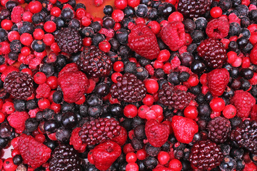 Frozen mixed berries as background. Blueberries,raspberries black berries and currant mulberry texture pattern.