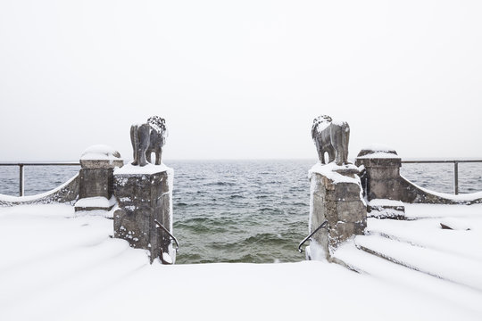 Snow-covered lion sculptures at lake Starnberg, Bavaria, Germany