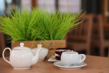 Kettle with a drink and dessert in a street cafe. Tea in the ket