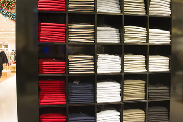 A row of folded jackets on a shelf in a store